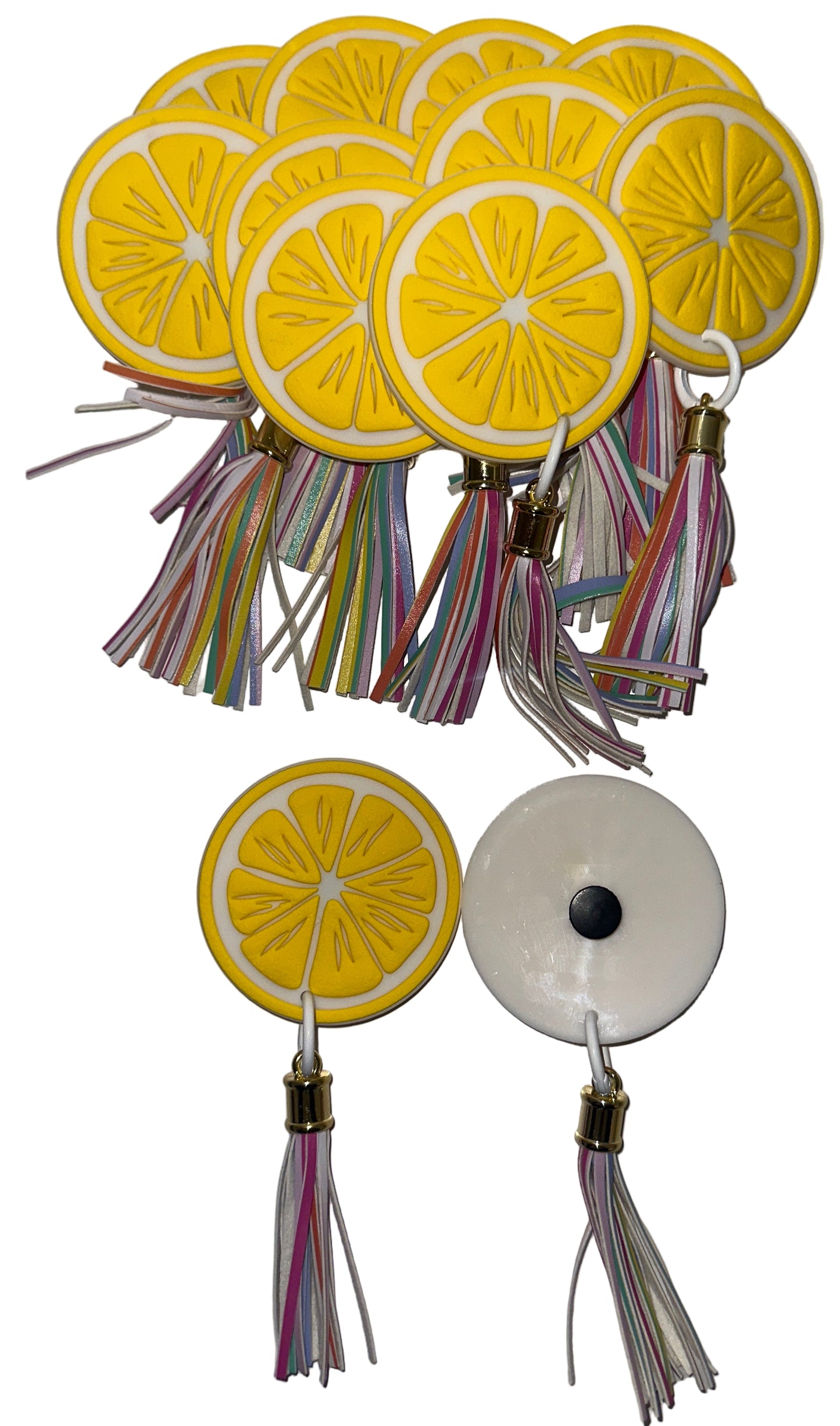 Yellow lemon slice keychains with tassels on a white background