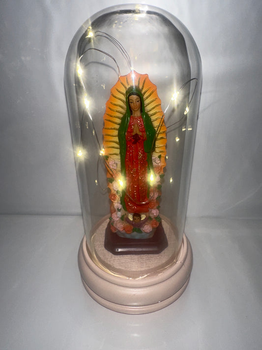 Decorative statue in a clear glass dome on a white background