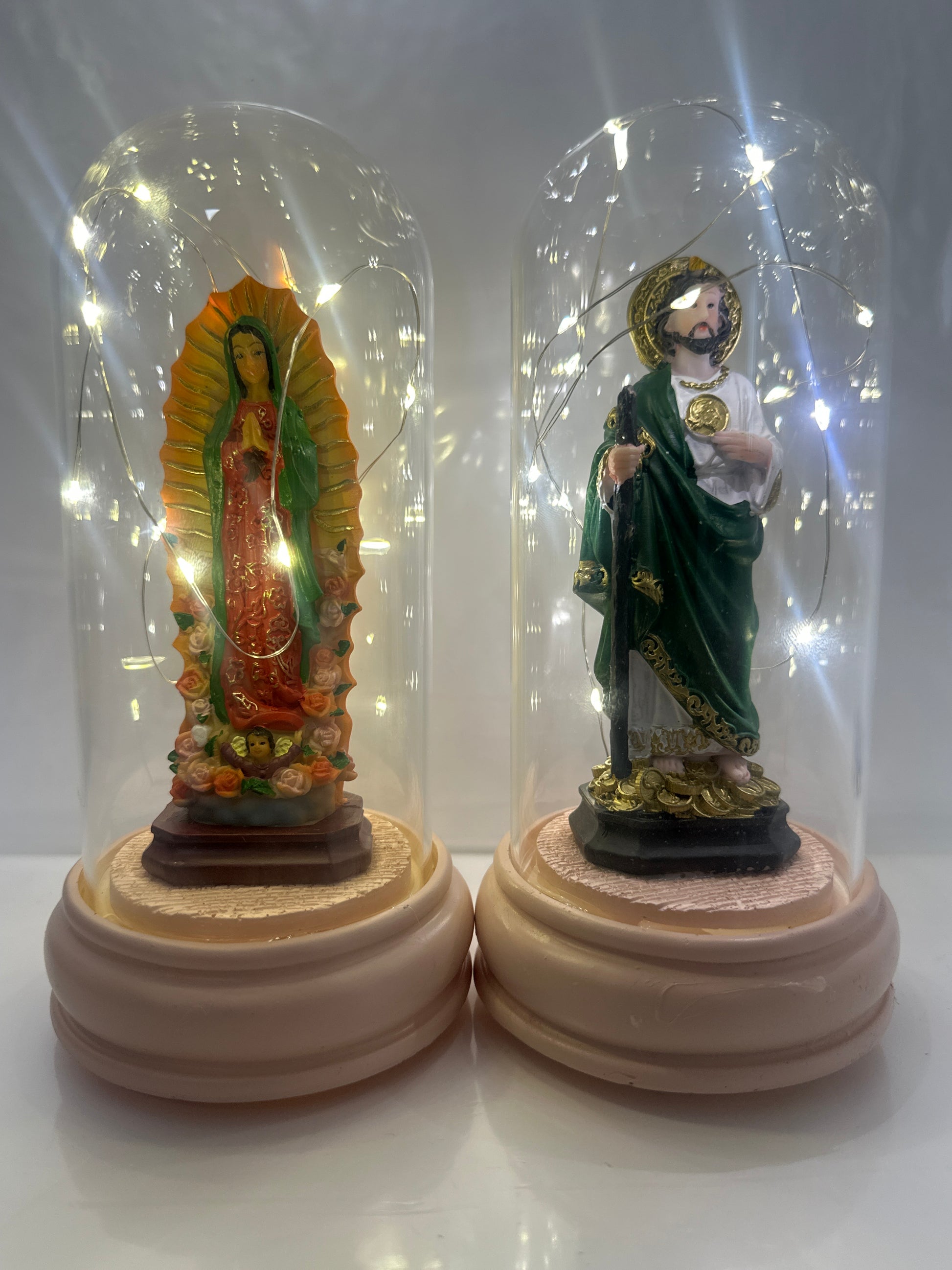 Decorative statue in a clear glass dome on a white background