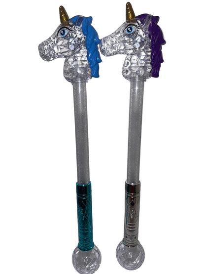 Two toy wands with unicorn designs, one with a blue head and the other with a purple head, both with multicolored bodies and standing upright.